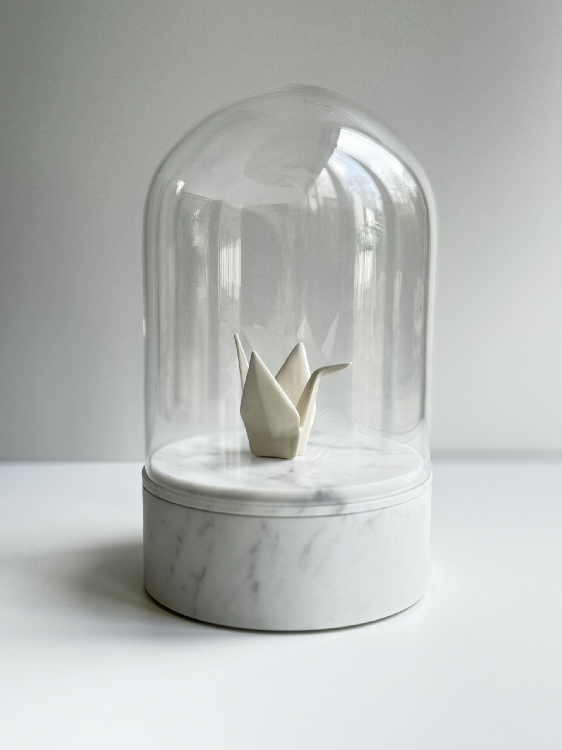Marmeren urn met glazen stolp en kraanvogel van porselein